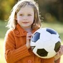 Niña con balón de fútbol en actividad deportiva